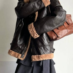 classic aviator bomber, women's RAF trench coat, warm lambskin bomber, WWII leather jacket, sheepskin pilot coat, vintage bomber style, retro fur coat women, distressed lambskin trench, handmade sheepskin bomber, leather winter coat, brown flight jacket, real shearling coat women, winter fur collar bomber, pilot-style leather jacket, thick lambskin coat, warm fur trench coat, stylish leather bomber, elegant shearling coat, vintage flight trench, WWII inspired bomber, cozy lambskin outerwear