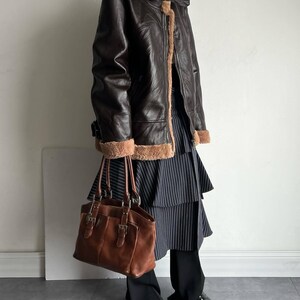 vintage shearling coat, B3 bomber leather, brown lambskin jacket, women's RAF bomber, distressed leather coat, fur collar trench, winter flight coat, warm sheepskin jacket, real leather bomber, retro style outerwear, pilot trench coat, WWII aviator jacket, classic flight bomber, women's winter coat, cozy fur bomber, real lambskin flight coat, handmade leather bomber, brown shearling jacket, soft fur collar jacket, heavy duty trench coat, luxury shearling bomber, heritage RAF trench coat