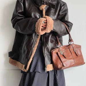 leather bomber jacket, vintage lambskin coat, women's B3 aviator coat, shearling flight jacket, warm fur collar coat, real sheepskin trench, brown distressed bomber, WWII style leather coat, retro trench outerwear, winter leather bomber, handmade lambskin jacket, fur cuffs bomber coat, cozy pilot jacket women, RAF sheepskin coat, vintage inspired trench, thick lambskin bomber, classic fur lined jacket, elegant leather coat women, aviator trench bomber, flight jacket retro style