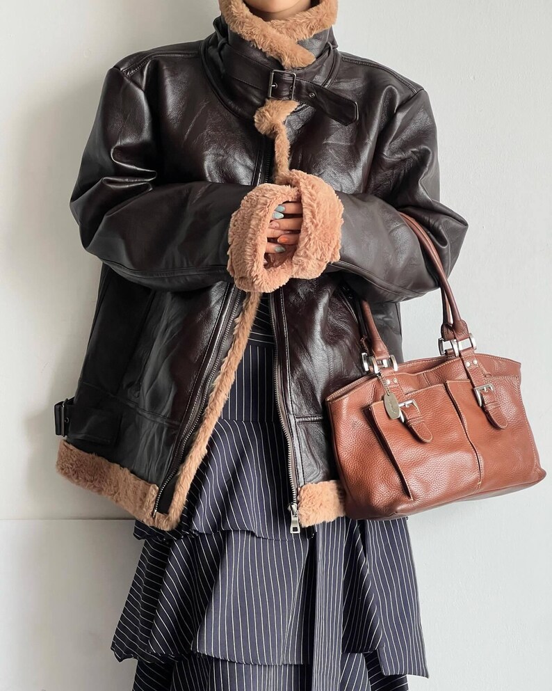 leather bomber jacket, vintage lambskin coat, women's B3 aviator coat, shearling flight jacket, warm fur collar coat, real sheepskin trench, brown distressed bomber, WWII style leather coat, retro trench outerwear, winter leather bomber, handmade lambskin jacket, fur cuffs bomber coat, cozy pilot jacket women, RAF sheepskin coat, vintage inspired trench, thick lambskin bomber, classic fur lined jacket, elegant leather coat women, aviator trench bomber, flight jacket retro style