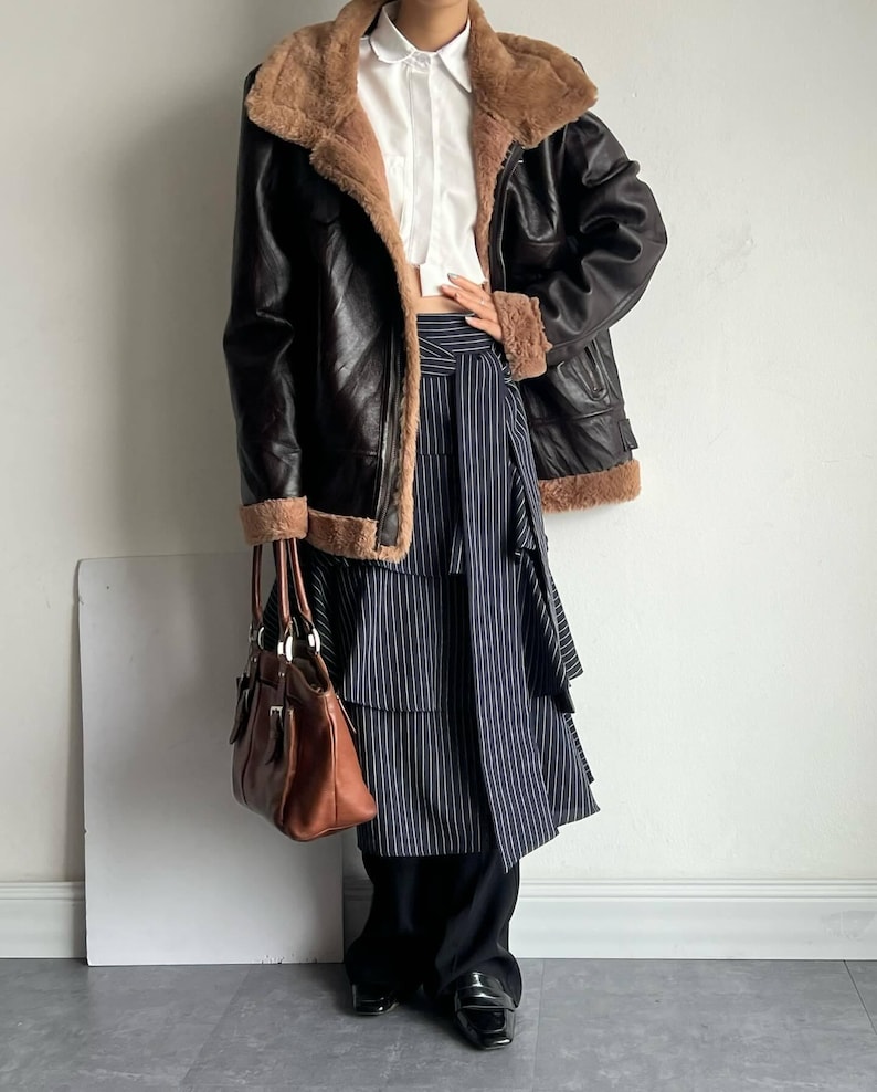 RAF bomber jacket, vintage women's flight coat, leather shearling outerwear, WWII aviator trench, warm brown lambskin coat, real sheepskin bomber, women's fur collar jacket, distressed flight bomber, cozy winter coat, handmade leather bomber, classic B3 aviator jacket, brown shearling flight coat, lambskin leather trench, fur cuff winter jacket, retro trench coat women, luxury winter outerwear, pilot bomber jacket, vintage lambskin bomber, elegant fur lined coat, women's heavy shearling coat