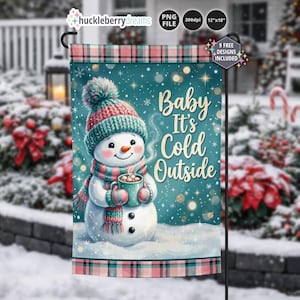 May include: A rectangular garden flag featuring a snowman wearing a pink and teal knit hat and scarf, holding a steaming mug. The teal background has white snowflakes and the text Baby It's Cold Outside. The flag has a pink and black plaid border.