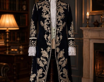Pode incluir: Um casaco de veludo azul-marinho escuro com bordados florais dourados intrincados nos painéis frontais e punhos. O casaco é usado sobre uma camisa branca com acabamento em renda e um colete verde-claro, exibido num manequim de madeira.