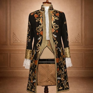 May include: A black embroidered coat with gold and orange floral patterns, displayed on a wooden mannequin. The coat has gold trim, white lace cuffs, and a high collar. The mannequin is set against a neutral background.