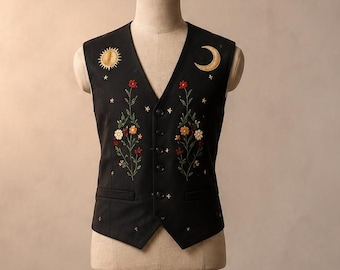 Completo da uomo nero con gilet e pantaloni ricamati a tema celeste, abito formale con motivo floreale sole e luna.