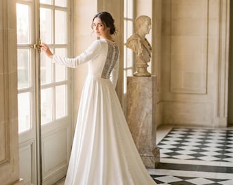 Abito da sposa su misura in raso avorio, linea ad A, con schiena scoperta e ricami.