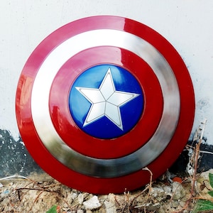 May include: A circular shield with a red, silver, and white concentric design. The centre has a blue circle with a white star. This shield is a replica of Captain America's shield.