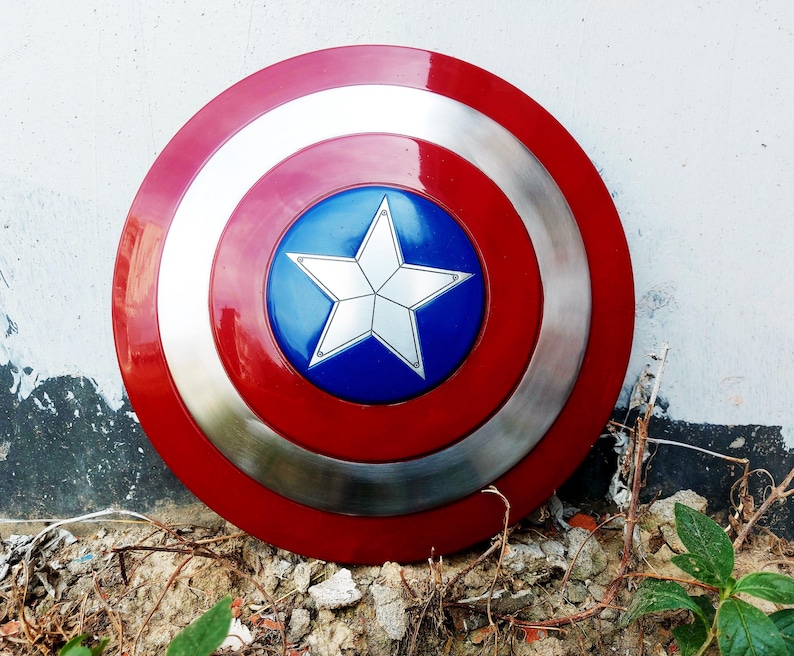 May include: A circular shield with a red, silver, and white concentric design. The centre has a blue circle with a white star. This shield is a replica of Captain America's shield.