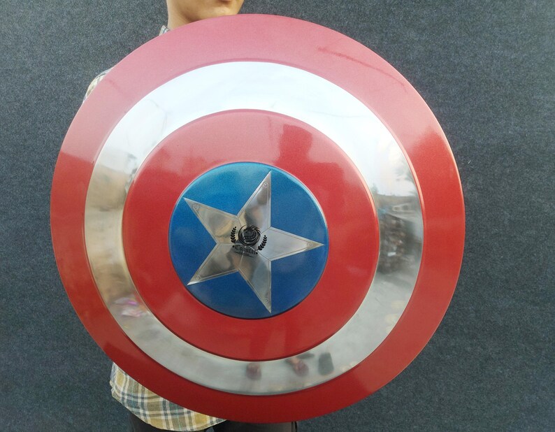 Op de afbeelding: Een rood, wit en blauw Captain America schild met een zilveren ster in het midden. Het schild heeft een zilveren rand en is gemaakt van metaal.