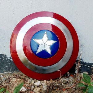 May include: A circular shield in red, silver, and blue. It has a central blue disc with a white star, encircled by silver and red rings. This shield is likely a prop or collectible item.
