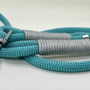 Könnte beinhalten: Eine tealblaue und silberne Hundeleine aus Seil mit einem silbernen Clip.