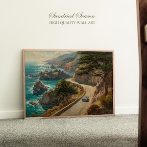 Op de afbeelding: Een ingelijste wandkunstprint met een kustlandschap met een kronkelende weg, zee en kliffen. Het kunstwerk heeft een vintage esthetiek, met een auto op de weg. De tekst "Sundried Season" en "HIGH QUALITY WALL ART" is zichtbaar.