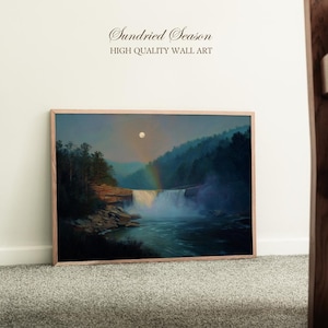 Pode incluir: Uma pintura de paisagem emoldurada retrata uma cachoeira caindo em um rio, com um arco-íris e uma lua cheia no céu. A obra de arte está em uma moldura de madeira e apresenta o texto "Sundried Season HIGH QUALITY WALL ART".