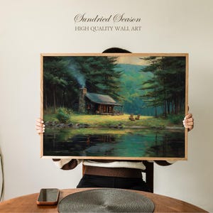 May include: A framed wall art print featuring a cabin scene with a lake and forest. The artwork has a wooden frame and depicts a cabin with smoke rising from the chimney. The text "Sundried Season" and "HIGH QUALITY WALL ART" is at the top.