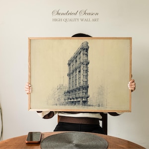 Op de afbeelding: Een ingelijste print van een gedetailleerde architectonische schets van een hoog, driehoekig gebouw. Het kunstwerk is in zwart-wit, tegen een beige achtergrond, en ingelijst in licht hout. De tekst "Sundried Season" en "HIGH QUALITY WALL ART" staat bovenaan.