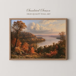 May include: A rectangular wall art print in a wooden frame featuring a landscape painting of a river winding through a forest with autumn foliage in shades of orange, red, and brown under a soft, cloudy sky. The text Sundried Season is visible.