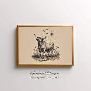 Könnte beinhalten: Gerahmter Druck mit einer detaillierten Schwarz-Weiß-Illustration eines Stiers, der in einem Grasfeld steht, mit Sternen darüber. Der Rahmen ist goldfarben. Der Text "Sundried Season" und "HIGH QUALITY WALL ART" befindet sich unten.