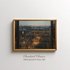 May include: A framed wall art print showing a cityscape from a balcony. The artwork depicts a dusk scene with buildings, lit windows, and a wrought iron balcony. The frame is gold, and the print has the text "Sundried Season" and "HIGH QUALITY WALL ART".