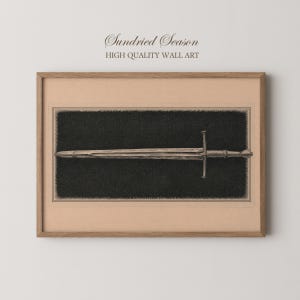 May include: A framed wall art print featuring a detailed black and white illustration of a sword centred on a dark textured background. The artwork is enclosed in a light brown wooden frame with the text Sundried Season High Quality Wall Art.