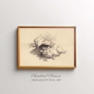 Op de afbeelding: Een ingelijste print met een gouden rand, met een zwart-wit tekening van een oog in een wolk, met zonnestralen. Het kunstwerk staat op een beige achtergrond. De tekst "Sundried Season" en "HIGH QUALITY WALL ART" staat onderaan de print.