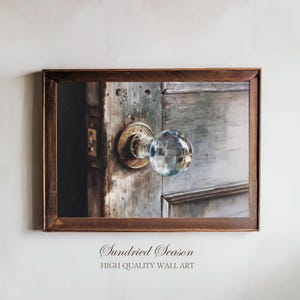 May include: A framed print depicting a detailed image of a vintage door with a crystal doorknob. The door is weathered with shades of grey and brown, and the doorknob is a clear, faceted sphere. The frame is a dark brown colour. Text at the bottom reads "Sundried Season, High Quality Wall Art."