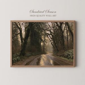 May include: A framed wall art print titled Sundried Season High Quality Wall Art, featuring a dark, misty forest road with tall, mossy trees and ferns lining the path, illuminated by soft, golden light reflecting on the wet ground surface.