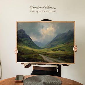 May include: A framed landscape art print featuring a scenic view of a valley with mountains, a road, and a small house. The artwork has a vintage aesthetic with a wooden frame. The text "Sundried Season" and "HIGH QUALITY WALL ART" are displayed at the top.