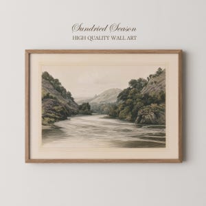 Può includere: Una stampa d'arte incorniciata intitolata Sundried Season High Quality Wall Art che presenta un'illustrazione paesaggistica color seppia di un fiume che scorre tra due colline alberate sotto un cielo pallido, in una cornice di legno marrone chiaro.