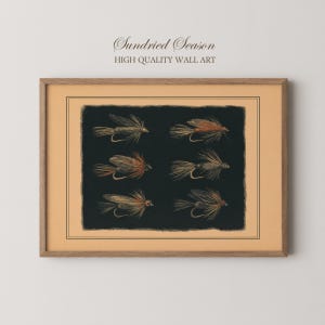 May include: A framed wall art print titled Sundried Season High Quality Wall Art featuring six detailed illustrations of fishing flies arranged in two columns on a dark black background, enclosed within a light tan border and a wooden frame.