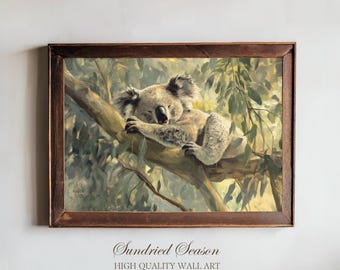 May include: A framed painting shows a koala bear asleep on a tree branch. The artwork has a brown wooden frame and the text "Sundried Season HIGH QUALITY WALL ART" at the bottom. The koala is painted in shades of grey and beige.