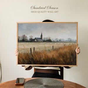 May include: A framed landscape painting depicting a church and field. The artwork shows a church with a tall spire in the distance, a field of tall grass, and a wooden frame. The text "Sundried Season HIGH QUALITY WALL ART" is at the top.