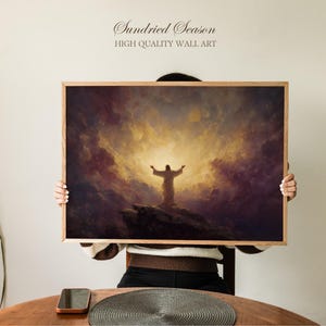 Puede incluir: Una impresión artística enmarcada que presenta una escena religiosa con una figura sobre una roca con los brazos extendidos, sobre un cielo dramático. La obra de arte está en un marco de madera, con el texto "Sundried Season HIGH QUALITY WALL ART" en la parte superior.