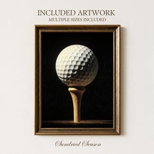 Op de afbeelding: Een ingelijste print met een golfbal op een houten tee tegen een donkere achtergrond. De golfbal is wit met putjes, de tee is lichtbruin. De lijst is donkerbruin, met de tekst "INCLUDED ARTWORK MULTIPLE SIZES INCLUDED" bovenaan en "Sundried Season" onderaan.