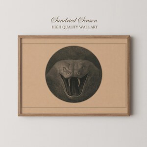 May include: A framed wall art print featuring a circular illustration of a snake with its mouth open, revealing fangs. The artwork is set against a tan background within a rectangular wooden frame. The text Sundried Season HIGH QUALITY WALL ART is printed above the frame.