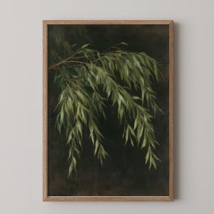 May include: A framed wall art print featuring a painting of drooping willow branches with long, slender green leaves. The foliage is depicted against a dark, moody, charcoal-colored background. The artwork is encased in a light-toned wooden frame.