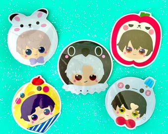 May include: Five colorful cartoon character stickers with different animal and food themes. Each sticker features a character with a different hairstyle and facial expression. The stickers are on a turquoise background.