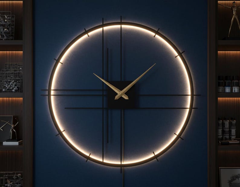 May include: A modern, round wall clock with a black frame and gold-colored hands. The clock features a glowing, circular light and a dark blue background. The clock's diameter is approximately 30 inches.