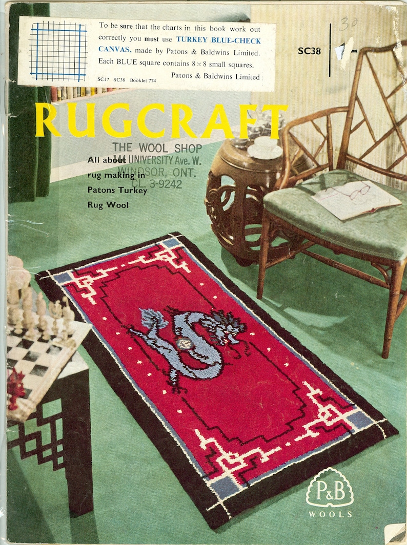 Pu&ograve; includere: Un tappeto rosso con un disegno di drago blu e un bordo nero e bianco. Il tappeto &egrave; su una superficie verde con una sedia di legno e una scacchiera sullo sfondo. Il testo "P&B WOOLS" &egrave; nell'angolo in basso a destra del tappeto.