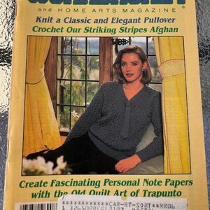 May include: The Workbasket and Home Arts Magazine cover from April 1986 features a woman wearing a blue and white striped sweater, sitting in front of a window. The magazine cover text reads "Knit a Classic and Elegant Pullover" and "Crochet Our Striking Stripes Afghan".