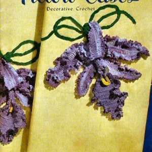 May include: A vintage crochet pattern book titled "Pillow Cases: Decorative Crochet" with a cover image of two purple and green crocheted flower pillowcases.