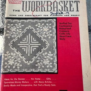 May include: The Workbasket magazine cover from February 1958 features a white crocheted snowflake design. The magazine title is in bold red letters and the subtitle is "Home and Needlecraft for Pleasure and Profit". The cover also lists various craft projects, including a stuffed toy, centerpiece, bedspread, creepers, calla lily, heart lace, and doily.