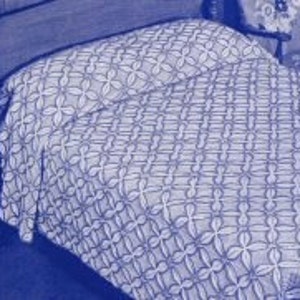 May include: A white crocheted bedspread with a repeating flower pattern.