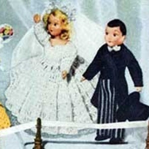 Puede incluir: Un conjunto de muñecas de novia y novio, la novia lleva un vestido de novia de encaje blanco con velo y el novio lleva un esmoquin negro con pajarita blanca y sombrero de copa.
