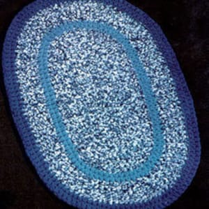 May include: A blue and white oval braided rug with a blue border.