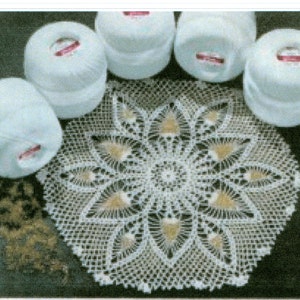May include: A white crocheted doily with a delicate floral design. Five white balls of yarn are arranged around the doily.