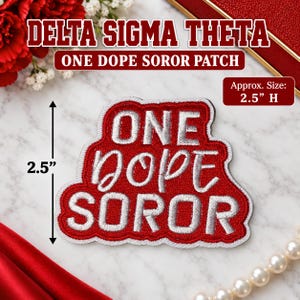 May include: An embroidered patch featuring the text ONE DOPE SOROR in silver thread on a red background. The patch has a white border and measures 6.35 cm in height. The design is centred and clearly legible against the fabric texture.
