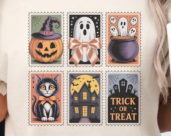 May include: Beige t-shirt featuring a Halloween-themed stamp design. The stamps depict a jack-o'-lantern, ghost, cauldron, black cat, haunted house, and the words "Trick or Treat". The shirt is a comfortable, casual style.