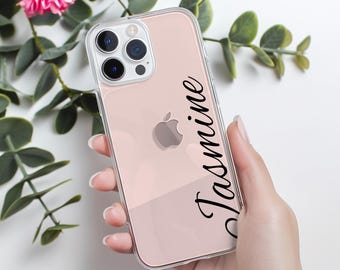 May include: A clear phone case with a pink and white design. The case has a black inscription that says "Jasmine".