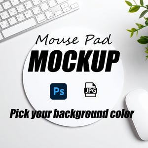 May include: A white mouse pad mockup with the text "Mouse Pad MOCKUP" in black. The image includes a computer keyboard, a computer mouse, and a small plant. The mouse pad has the text "Pick your background color".