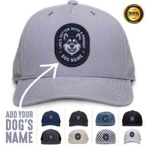 Pode incluir: Um boné de beisebol cinza com um remendo preto que apresenta um cão Pomsky de desenho animado e o texto "Life's Better With a Pomsky" e "Dog Name".